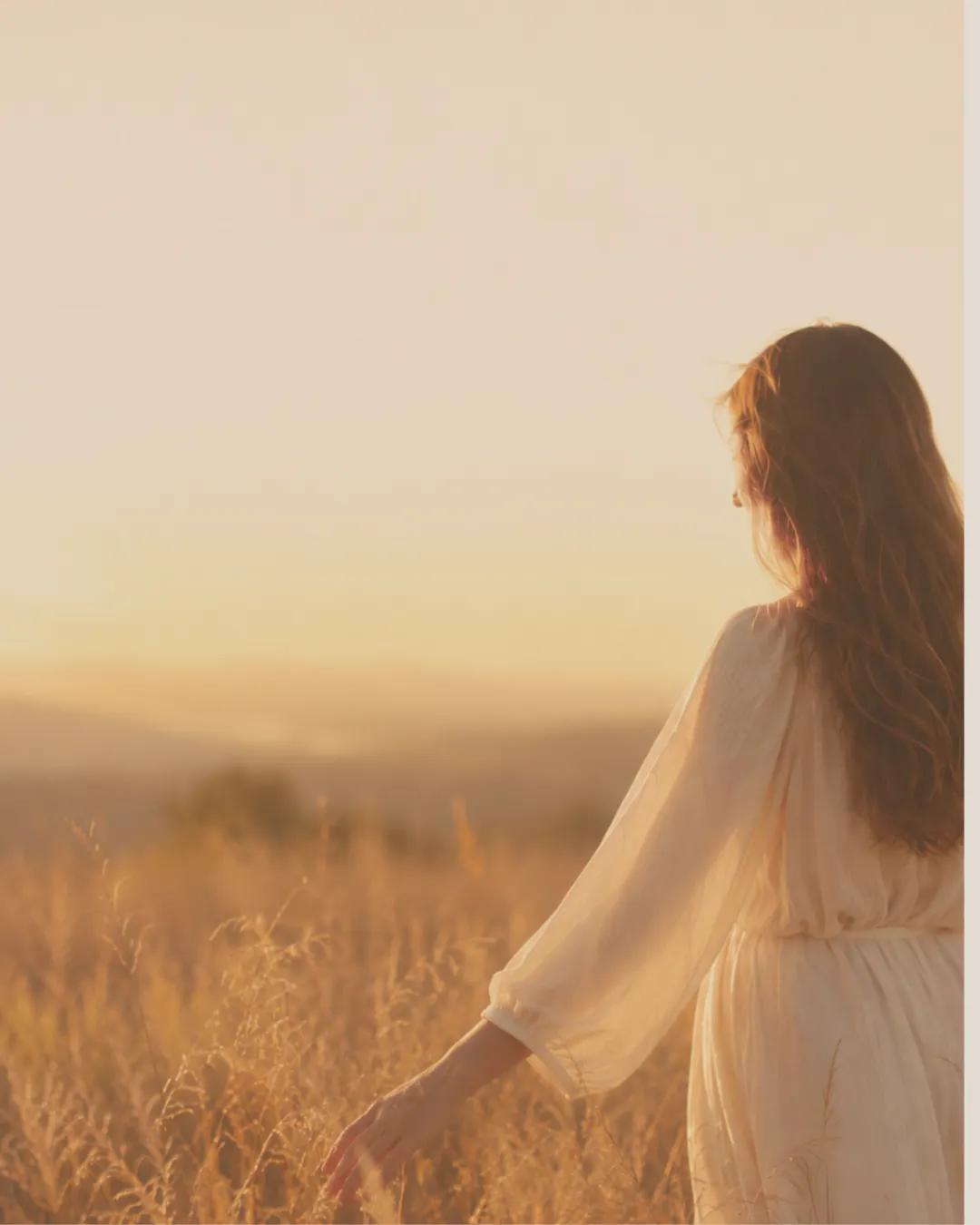 Woman looking across coastal countryside in the evening light
